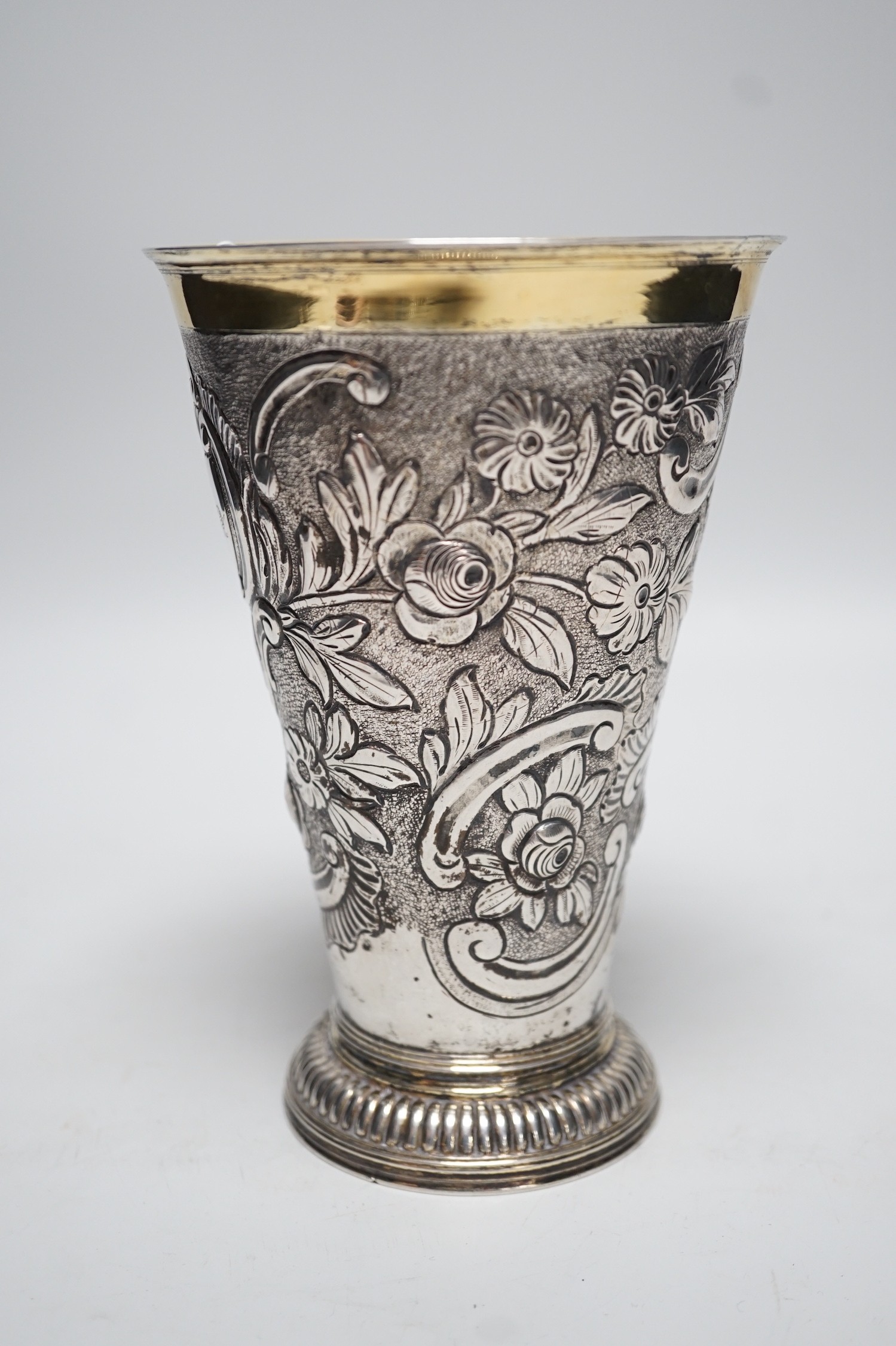 A 19th century Swiss? embossed parcel gilt white metal flared vase, maker's mark AWM, engraved with two armorials, height 17cm, 10.8oz.